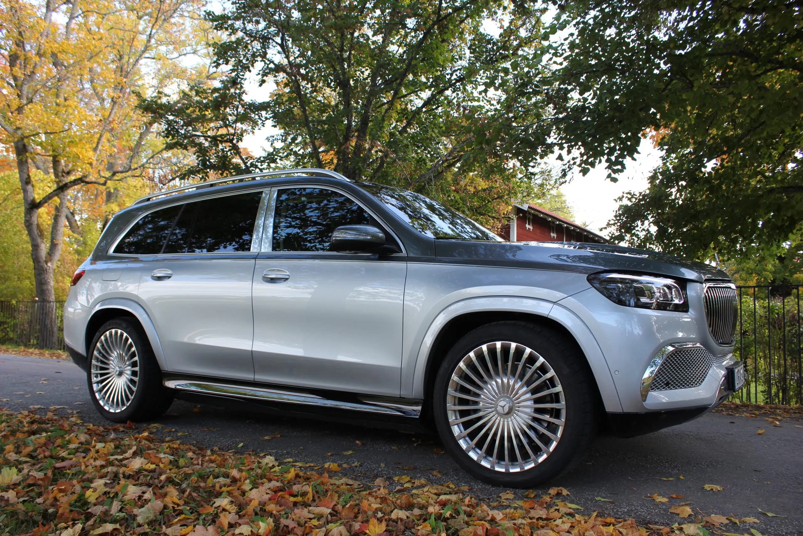 A silver Mercedes-Maybach GLS parked on a tree-lined Stockholm road.